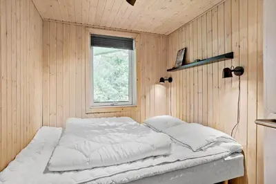a bed in a room with a window at BL1774-Blokhus-Ronliensvej-11 in Blokhus