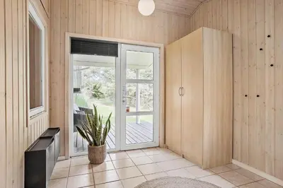 a room with a sliding glass door with a potted plant at BL1774-Blokhus-Ronliensvej-11 in Blokhus