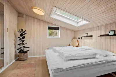 a bedroom with a large white bed with a skylight at BL1774-Blokhus-Ronliensvej-11 in Blokhus