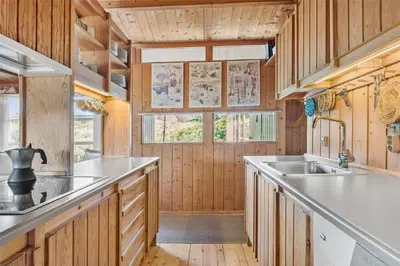 a kitchen with wooden cabinets and a sink at BL199-Saltum-Daadyrvej-22 in Saltum