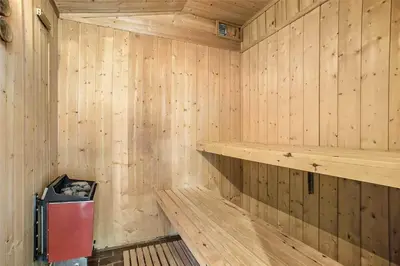 a wooden sauna with a red trash can in it at BL199-Saltum-Daadyrvej-22 in Saltum