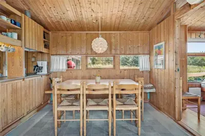 a wooden kitchen with a table and chairs at BL199-Saltum-Daadyrvej-22 in Saltum
