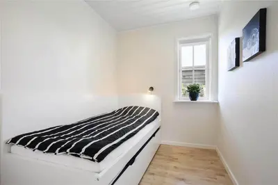 a white room with a bed and a window at BL475-Blokhus-Peder-Madsensvej-21 in Blokhus