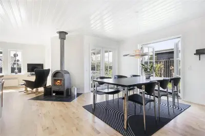 a dining room with a table and a wood stove at BL475-Blokhus-Peder-Madsensvej-21 in Blokhus
