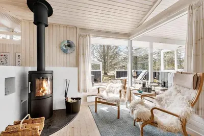 a living room with a fireplace and a couch and chairs at BL1461-Saltum-Kvansletten-29 in Saltum