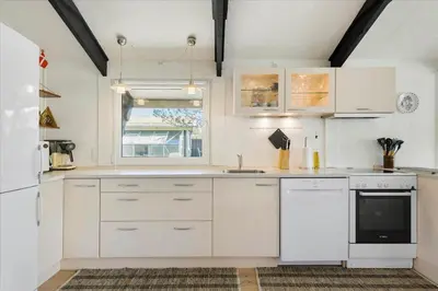 a kitchen with white cabinets and a window at BL794-Pandrup-Hunetorp-Klitvej-113 in Pandrup