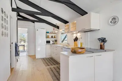 a kitchen with white cabinets and a white refrigerator at BL794-Pandrup-Hunetorp-Klitvej-113 in Pandrup