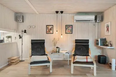 two chairs in a room with a desk and a heater at BL1451-Blokhus-Quintusvej-5 in Blokhus