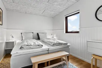 a white bedroom with a bed and a window at BL980-Saltum-Faarup-Klitvej-46 in Saltum