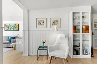 a white living room with a chair and a table at BL980-Saltum-Faarup-Klitvej-46 in Saltum
