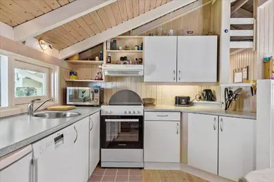 a kitchen with white cabinets and a sink at BL565-Pandrup-Lunekrogen-22 in Pandrup