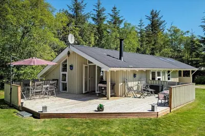 a house with a large deck with a grill at BL565-Pandrup-Lunekrogen-22 in Pandrup