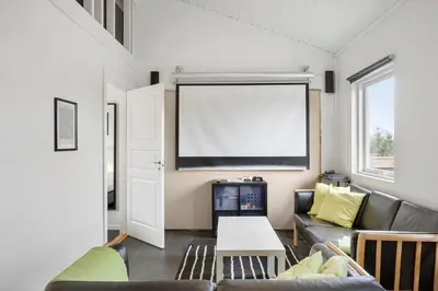 a living room with a couch and a large screen at BL106-Saltum-Tolhoj-2 in Saltum