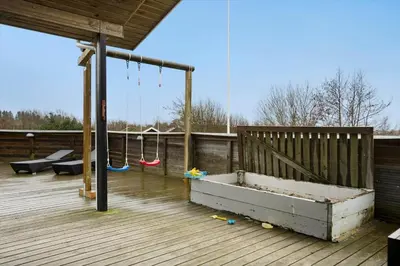 a wooden deck with a swing and a sandbox at BL106-Saltum-Tolhoj-2 in Saltum