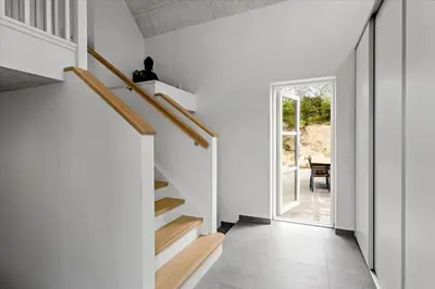 a hallway with white walls and wooden stairs at BL1506-Saltum-Kronhjortvej-15 in Saltum