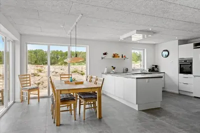 a kitchen and dining room with a table and chairs at BL1506-Saltum-Kronhjortvej-15 in Saltum