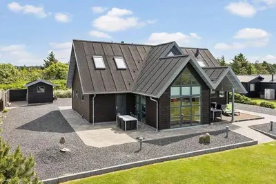 a house with a metal roof on a driveway at BL1509-Blokhus-Stromsvej-7 in Blokhus