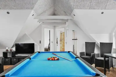 a pool table in a living room with chairs at BL1509-Blokhus-Stromsvej-7 in Blokhus