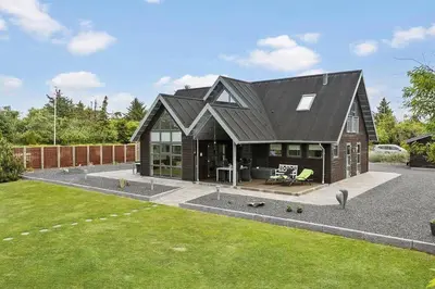 a house with a black roof and a yard at BL1509-Blokhus-Stromsvej-7 in Blokhus
