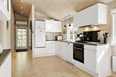 a kitchen with white appliances and a wooden ceiling at BL387-Blokhus-Berberisvej-51 in Blokhus