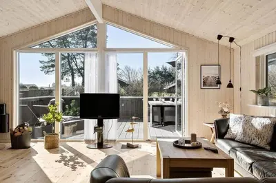 a living room with a couch and a large window at BL387-Blokhus-Berberisvej-51 in Blokhus