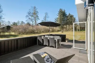 a patio with a table and an umbrella at BL387-Blokhus-Berberisvej-51 in Blokhus