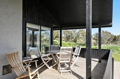 a deck with chairs and a table on a house at BL1408-Pandrup-Hunetorp-Klitvej-243 in Pandrup