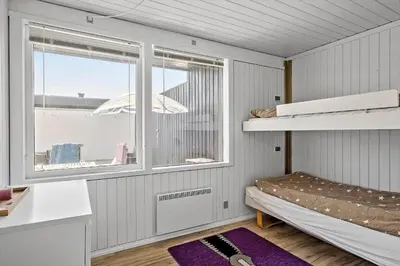 a small room with a bunk bed and a window at BL1398-Pandrup-Rodhus-Klitvej-135 in Pandrup