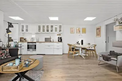 a living room and kitchen with a table and a couch at BL1398-Pandrup-Rodhus-Klitvej-135 in Pandrup