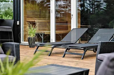 two black chairs sitting on a deck in front of a house at BL425-Saltum-Tippen-22 in Saltum