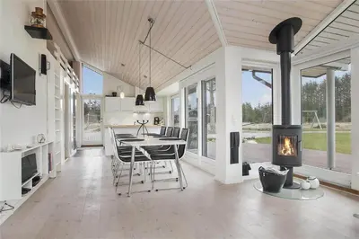 a kitchen and dining room with a fireplace in a house at BL425-Saltum-Tippen-22 in Saltum