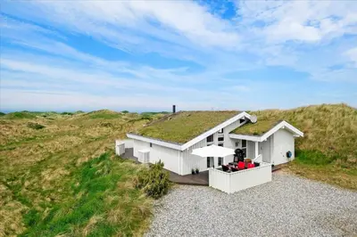 a white house with a grass roof on a hill at BL1772-Saltum-Faarup-Klitvej-22 in Saltum