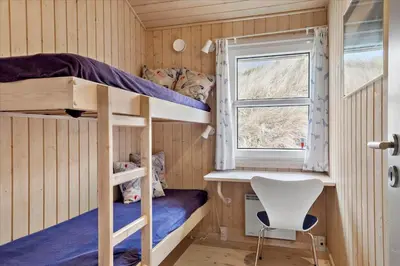 a bedroom with bunk beds and a window at BL1772-Saltum-Faarup-Klitvej-22 in Saltum