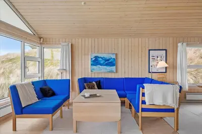 a living room with blue chairs and a table at BL1772-Saltum-Faarup-Klitvej-22 in Saltum