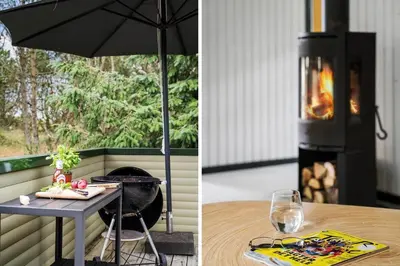 a table with an umbrella next to a fireplace at BL1365-Pandrup-Hunetorp-Klitvej-69 in Pandrup