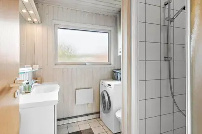 a bathroom with a sink and a washing machine at BL1256-Blokhus-Risen-32 in Blokhus