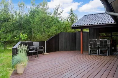 a wooden deck with a gazebo and tables and chairs at BL160-Blokhus-Bag-Hojen-68 in Blokhus