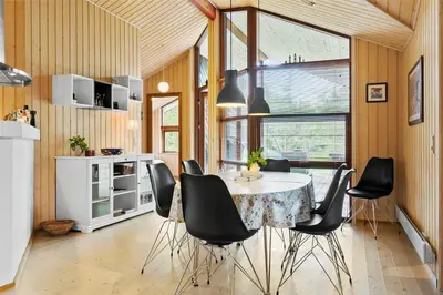a kitchen with a table and some black chairs at BL160-Blokhus-Bag-Hojen-68 in Blokhus