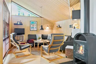 a living room with a wood stove in a room at BL160-Blokhus-Bag-Hojen-68 in Blokhus