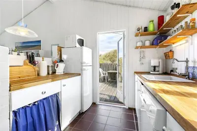 a kitchen with a refrigerator and a counter with a table at BL745-Saltum-Karen-Mariesvej-70 in Saltum