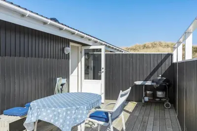 a patio with a table and chairs on a deck at BL826-Saltum-Haresvinget-7 in Saltum