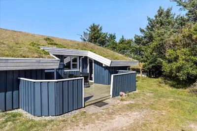 a house with a grass roof with a wooden deck at BL152-Saltum-Kvansletten-33 in Saltum