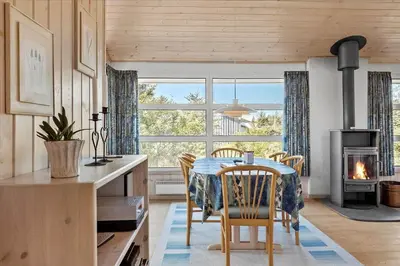 a kitchen with a table and chairs and a fireplace at BL152-Saltum-Kvansletten-33 in Saltum
