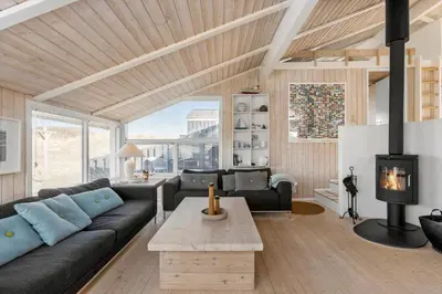a living room with a couch and a fireplace at BL1047-Saltum-Bag-Havstokken-2-A in Saltum