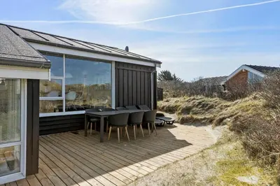 a wooden deck with a table and chairs on it at BL1047-Saltum-Bag-Havstokken-2-A in Saltum