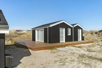 a black tiny house on a wooden deck at BL1047-Saltum-Bag-Havstokken-2-A in Saltum