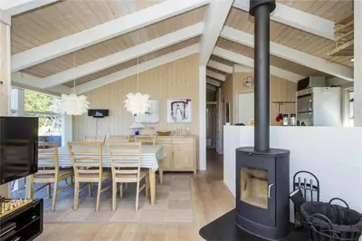 a kitchen and dining room with a wood stove at BL486-Saltum-Laustvej-32 in Saltum