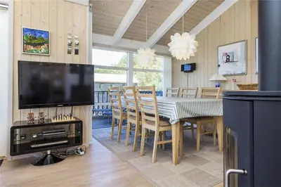 a dining room with a television and a table with chairs at BL486-Saltum-Laustvej-32 in Saltum