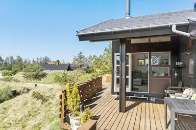 a house with a wooden deck with a patio at BL1702-Blokhus-Krylevej-3 in Blokhus