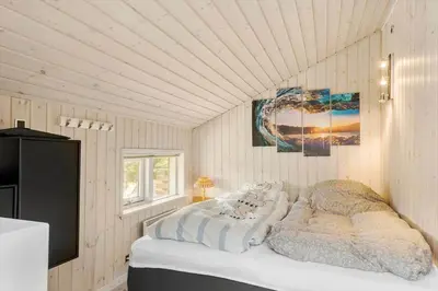 a bedroom with a bed and a television in it at BL1702-Blokhus-Krylevej-3 in Blokhus